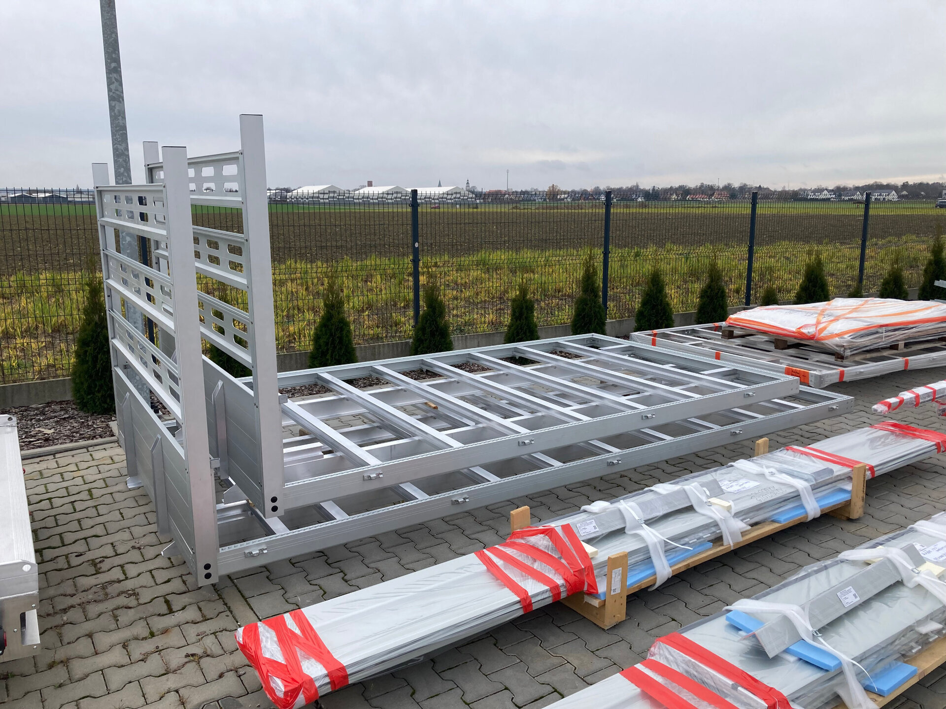 metalowe elementy skrzyni samochodowej ułożone na placu zewnętrznym